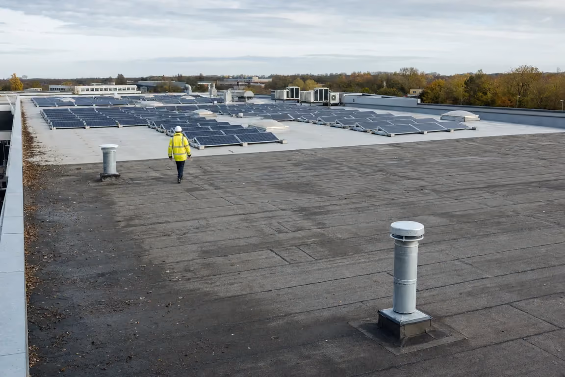 Solarpflicht nach der Dachsanierung: PV-Reihen auf frisch abgedichteter Teilfläche, die übrige Dachfläche noch frei